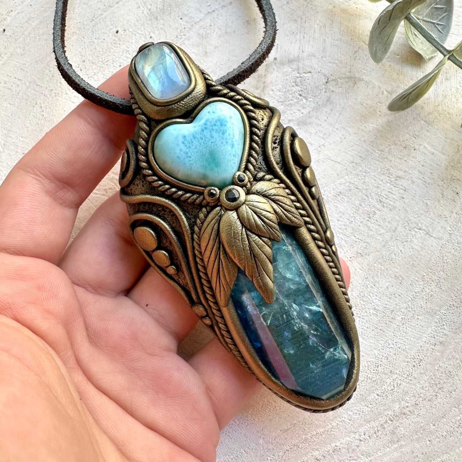 Handmade Aqua Aura Quartz healing crystal wand and pendant necklace featuring a Larimar Heart, Rainbow Moonstone and Blue Sapphire. A one of a kind spiritual energy tool combining luminous blue crystals and natural gemstones, designed for meditation, intention setting and personal spiritual practice.
