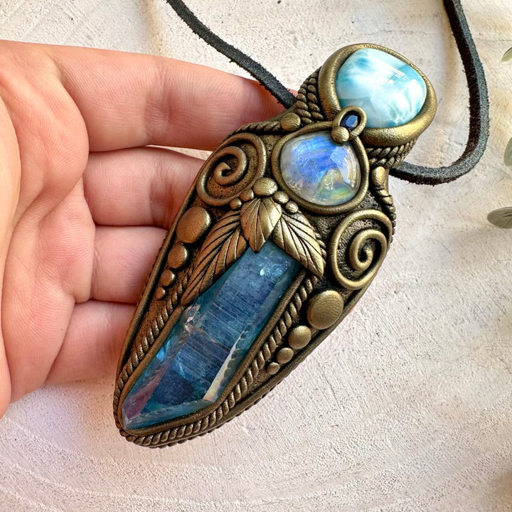 Aqua Aura Quartz healing crystal talisman combining luminous blue crystals with natural gemstones, inspired by intuition, clarity, calm, emotional balance and spiritual connection.