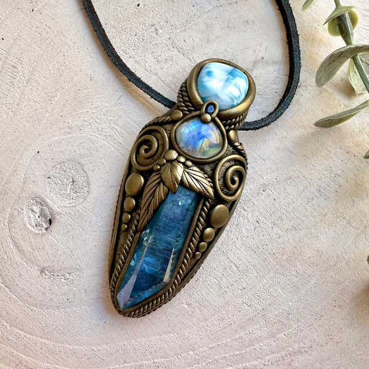 Natural gemstone pendant showcasing iridescent Rainbow Moonstone with deep blue Sapphire accents.