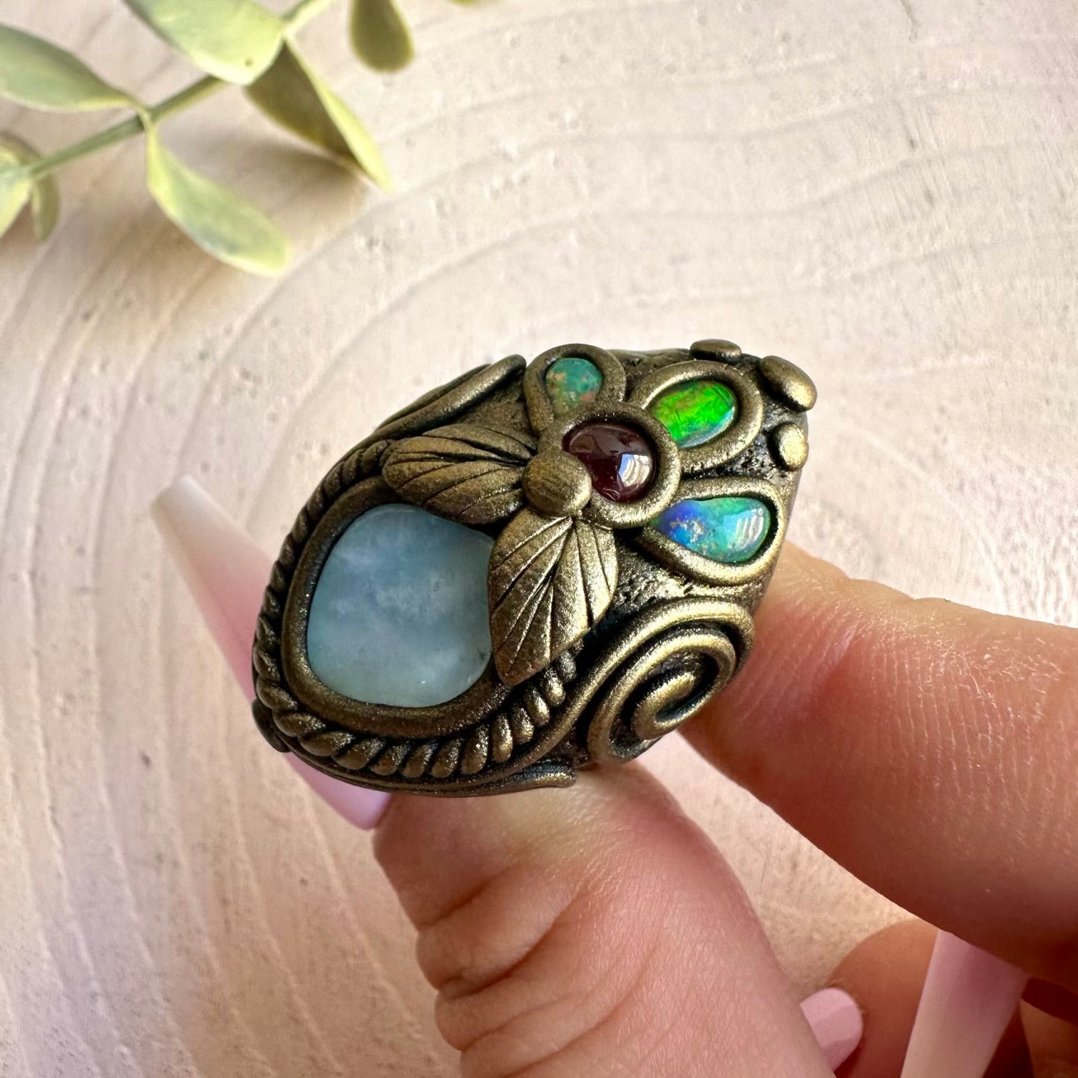 Handmade healing crystal ring featuring Aquamarine, Ethiopian Opal and natural Rhodolite Garnet.