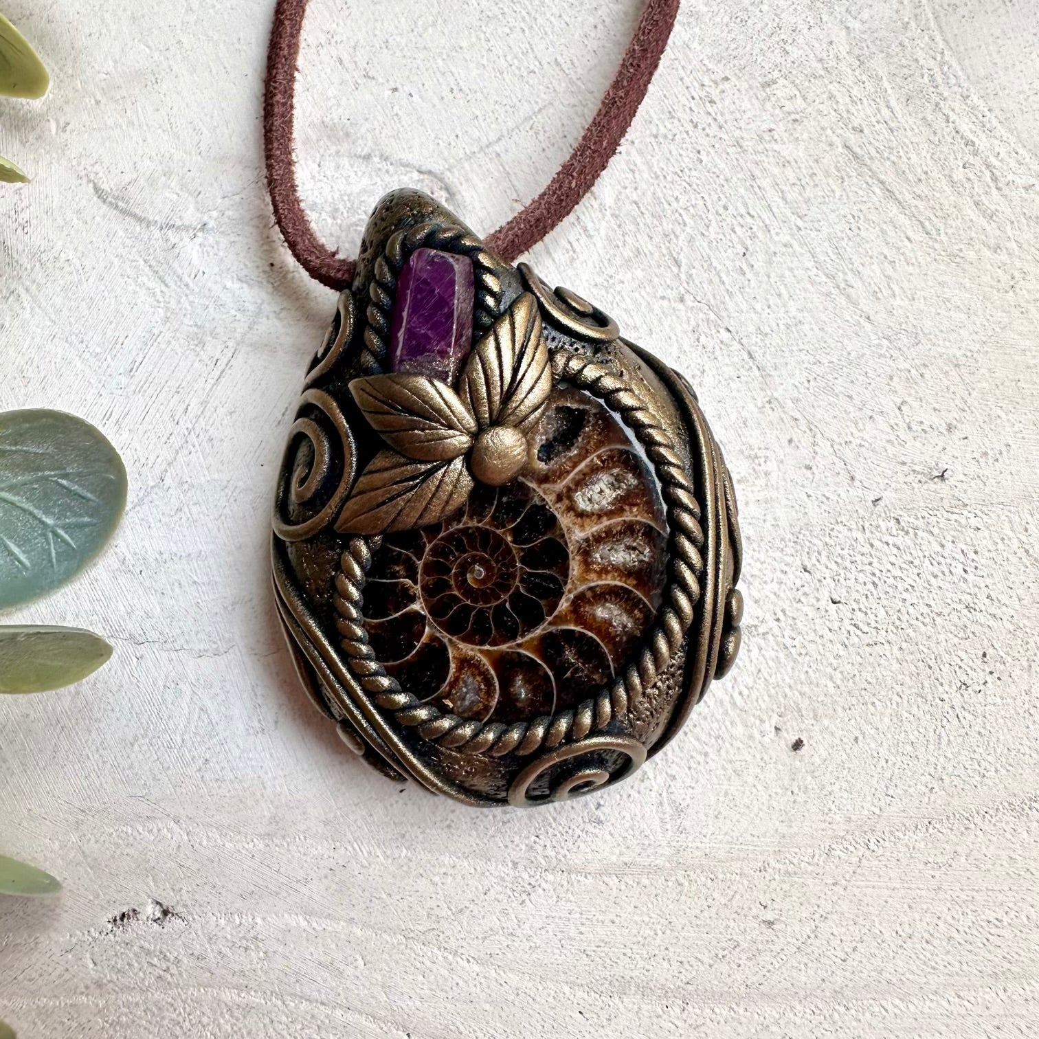 Witchy crystal necklace with Ammonite fossil and Ruby talisman pendant for mystical rituals and protection.