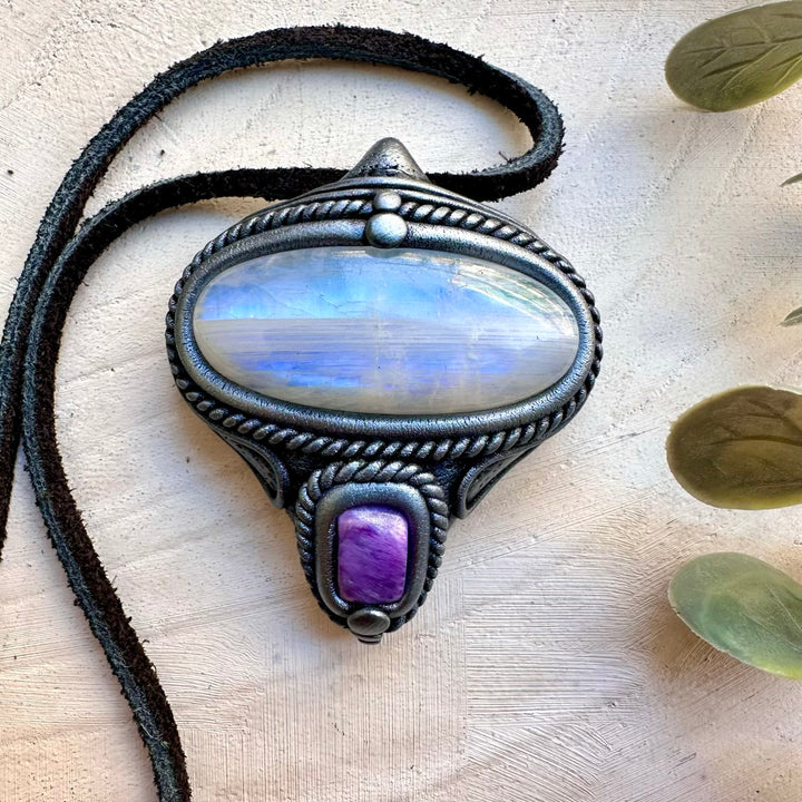 Close up of rainbow moonstone and charoite crystal pendant