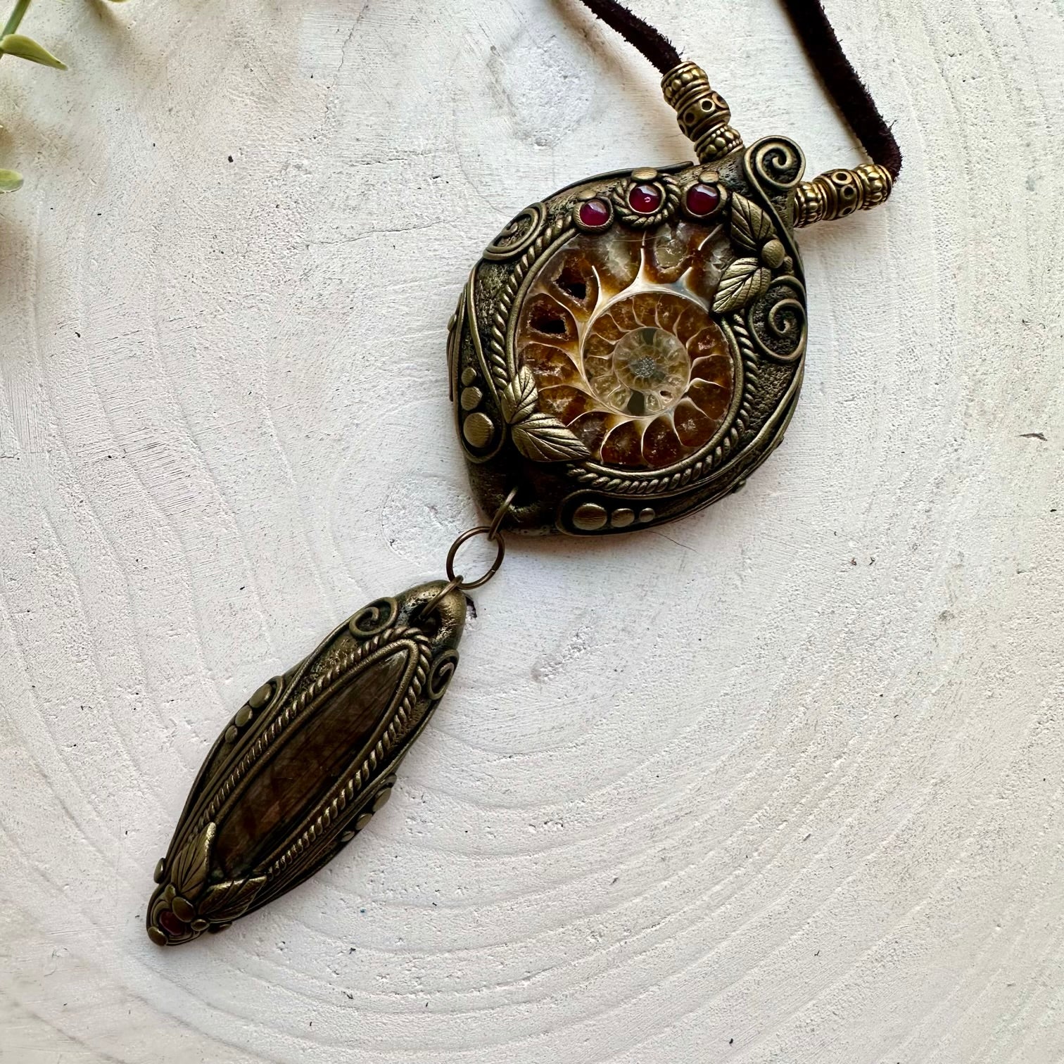Boho gemstone pendant showcasing an Ammonite fossil with Labradorite and Garnet accents.