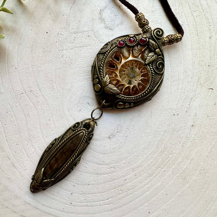 Boho gemstone pendant showcasing an Ammonite fossil with Labradorite and Garnet accents.