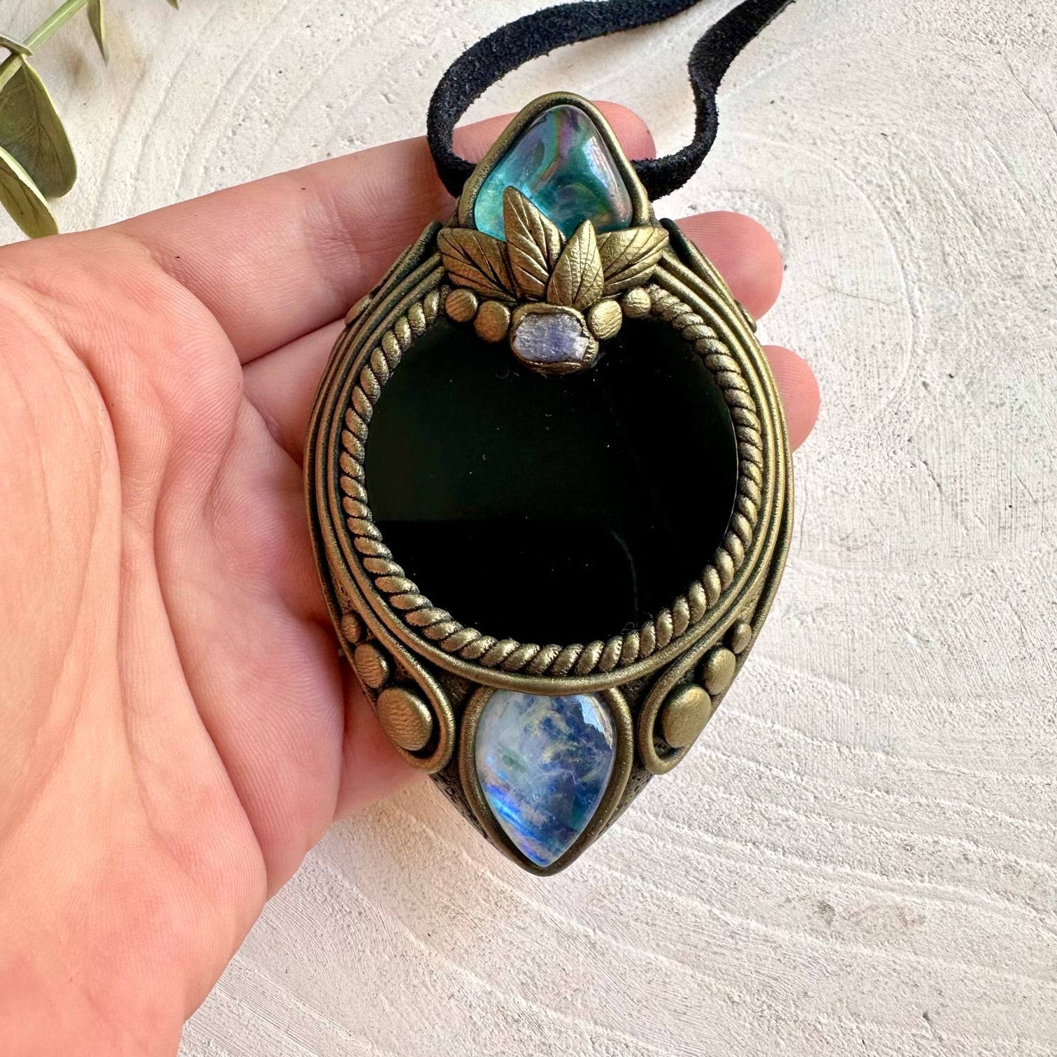 Handmade Black Obsidian Mirror pendant necklace featuring Aqua Aura Quartz, Rainbow Moonstone and Raw Tanzanite, a one of a kind crystal talisman combining deep reflective Obsidian with luminous natural gemstones.