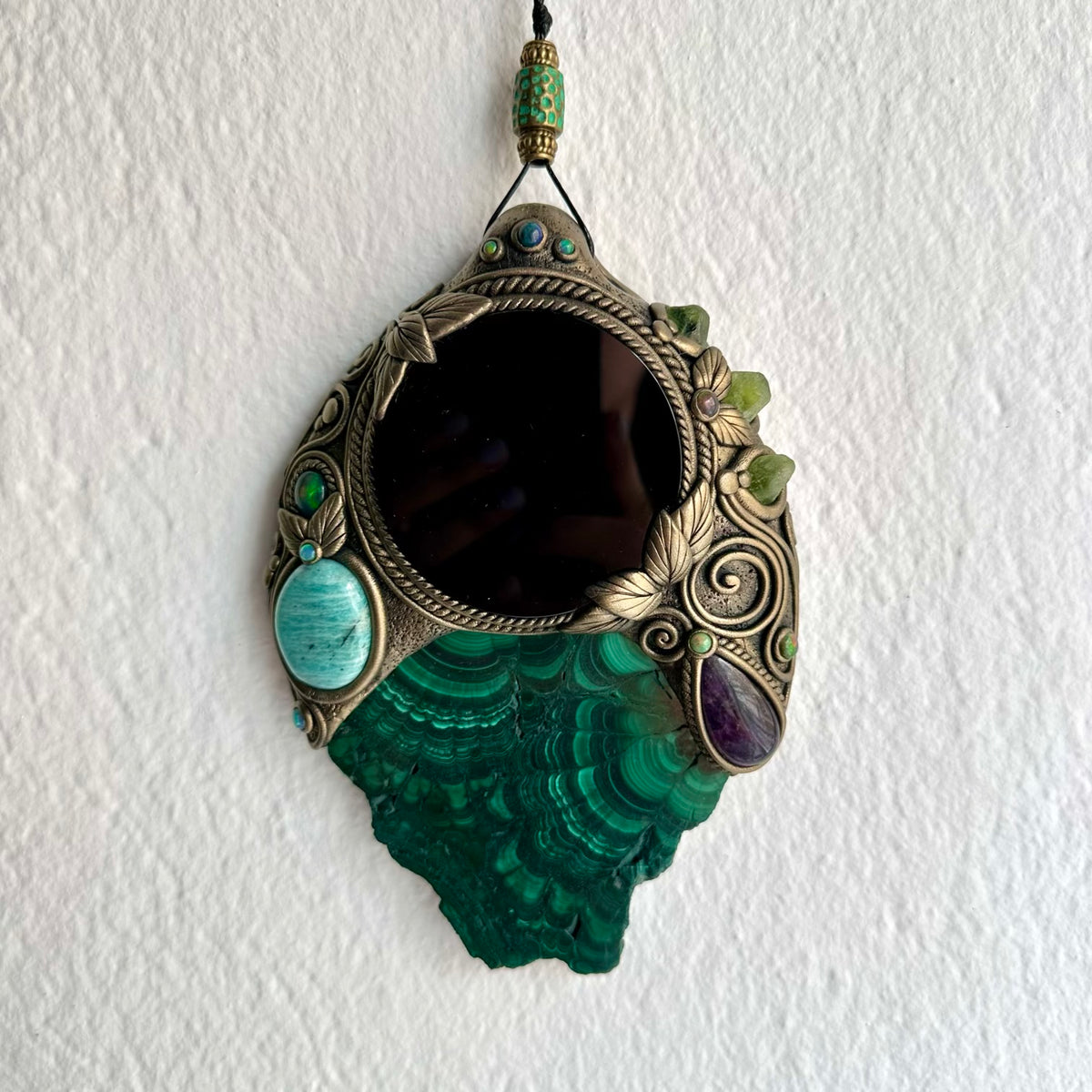 Artisan crystal mirror wall hanging decorated with natural Malachite, green Peridot and colorful Black Ethiopian Opal.
