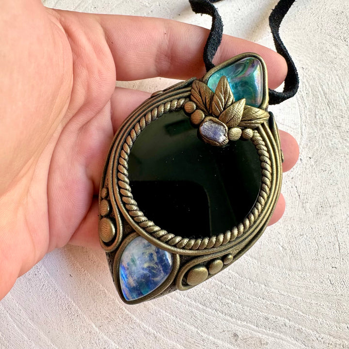 One of a kind crystal necklace featuring a polished Black Obsidian Mirror with shimmering natural gemstones.