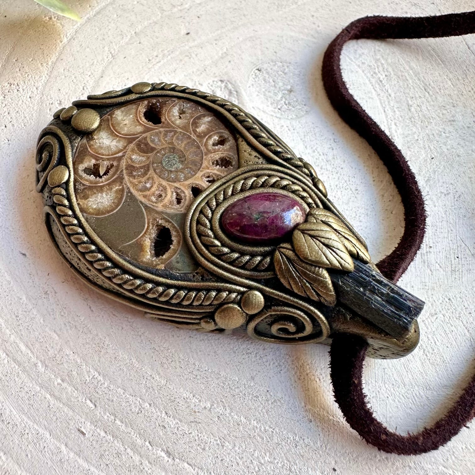 Artisan pendant necklace showcasing Ammonite, Black Tourmaline and natural Ruby gemstones.