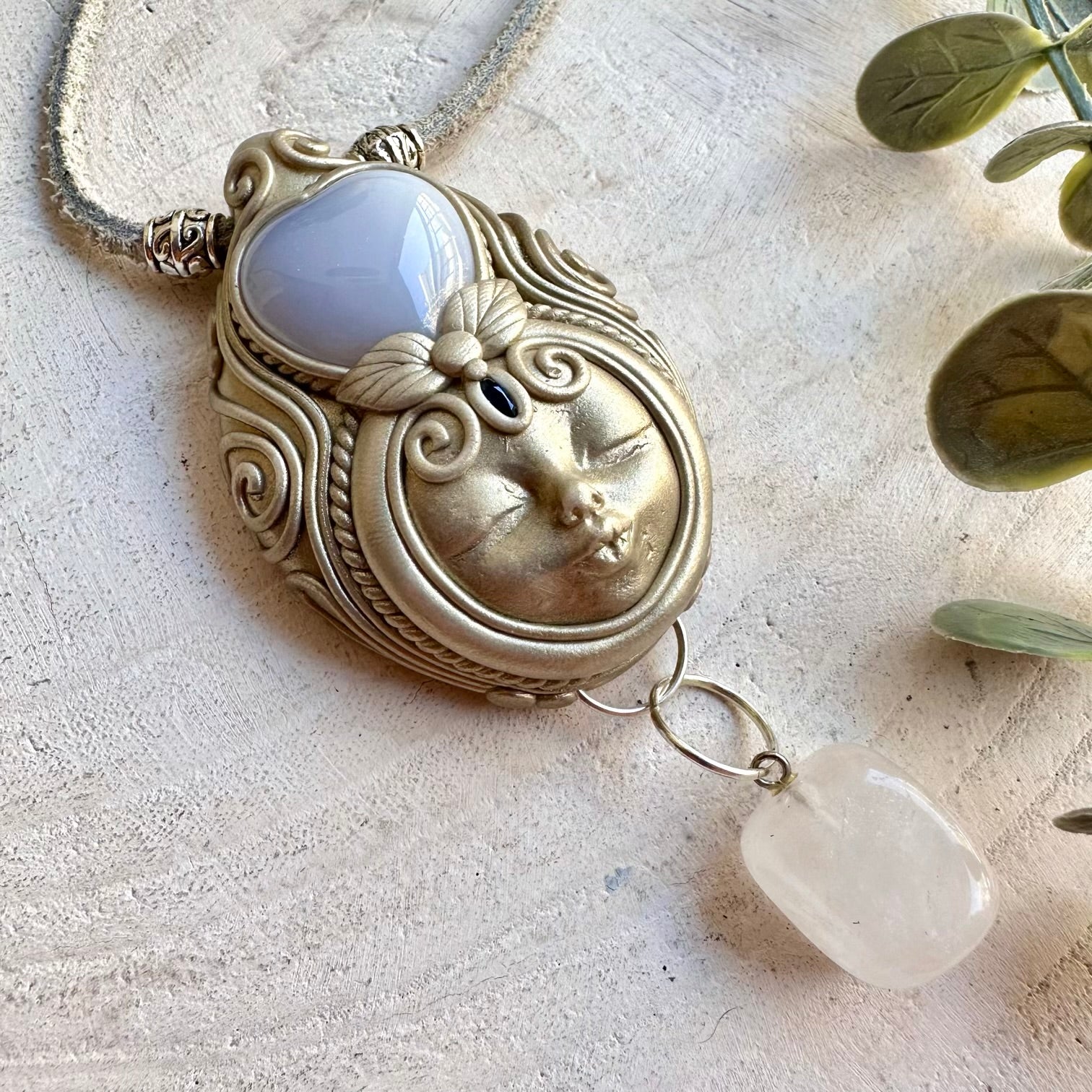 Artisan pendant showcasing a soft blue Chalcedony Heart with luminous Clear Quartz and natural Blue Sapphire.