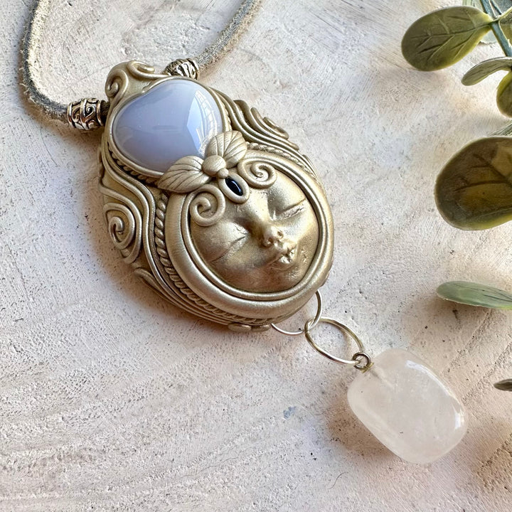 Artisan pendant showcasing a soft blue Chalcedony Heart with luminous Clear Quartz and natural Blue Sapphire.