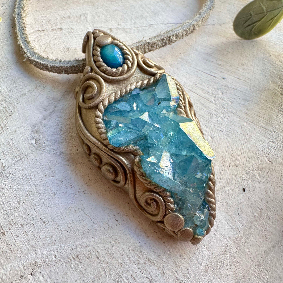 Unique gemstone pendant featuring an Aqua Aura Quartz Cluster and glowing blue Ethiopian Opal.