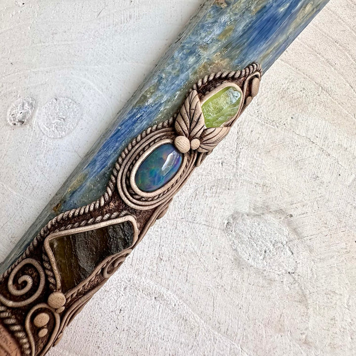 Unique gemstone talisman featuring Blue Kyanite with an ancient Ammonite fossil and raw green Moldavite, inspired by traditional metaphysical symbolism.