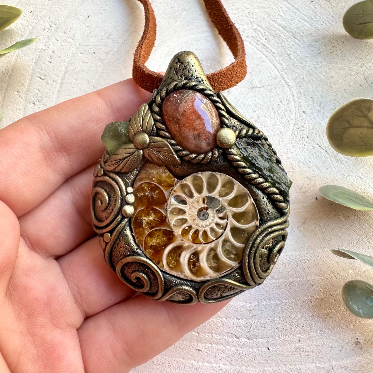 Handmade gemstone necklace combining an Ammonite fossil with Sunstone, Moldavite and Peridot.