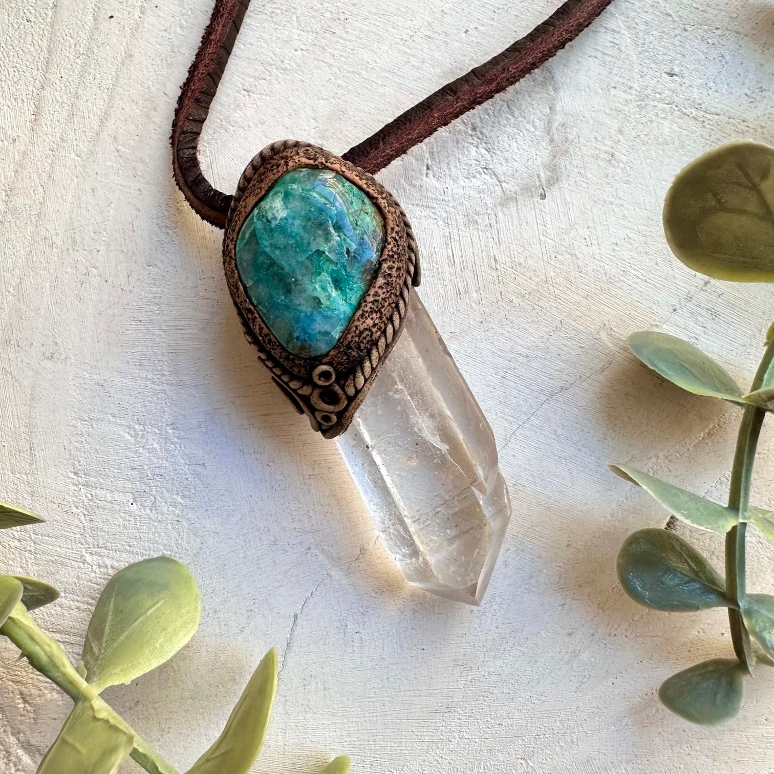 Close up of long clear quartz point and chrysocolla pendant