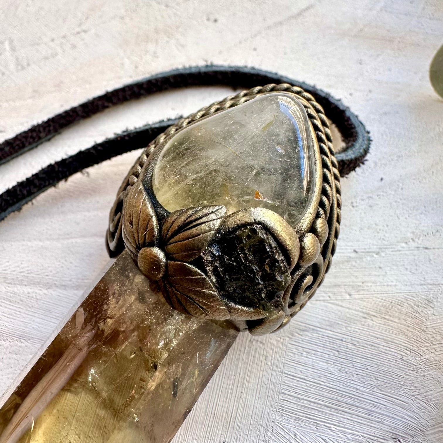 Close up of polished citrine topaz and moldavite crystal pendant