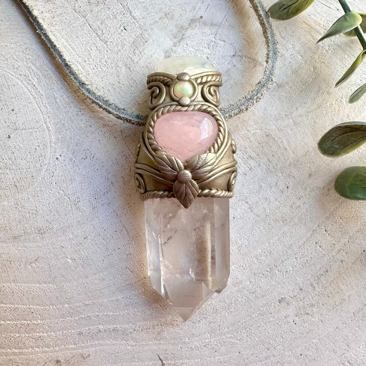 Handmade crystal wand necklace featuring a delicate Rose Quartz Heart alongside luminous Moonstone, natural Ethiopian Opal and Clear Quartz, this enchanting crystal wand necklace blends mystical beauty with powerful symbolic energy. A unique spiritual gemstone talisman for meditation, energy work, intention setting and everyday wear.