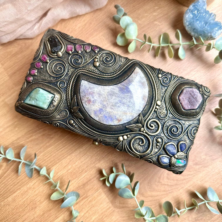 Top view of handmade crystal box featuring a large moonstone moon with ruby, emerald and healing gemstones