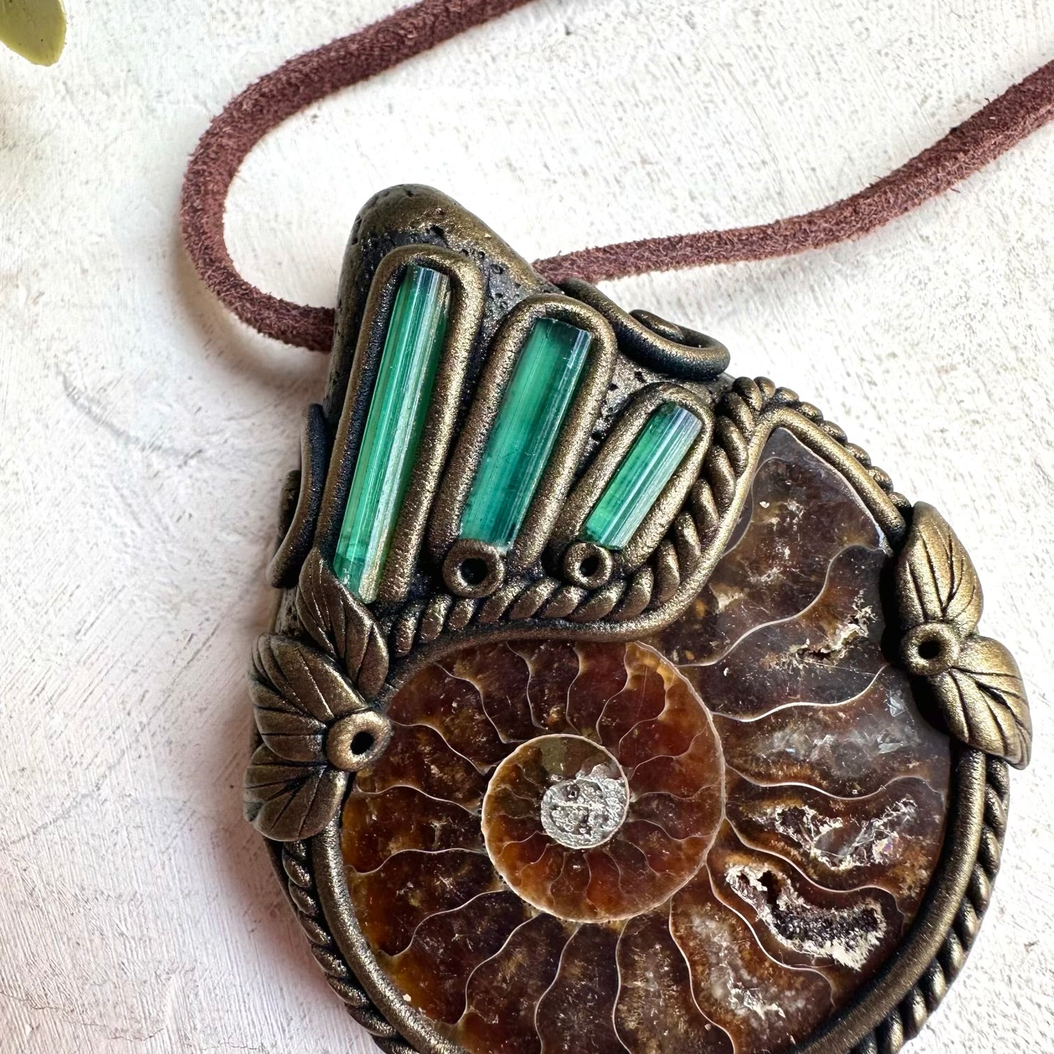 Crystal necklace for luck and abundance featuring green tourmaline and ammonite fossil