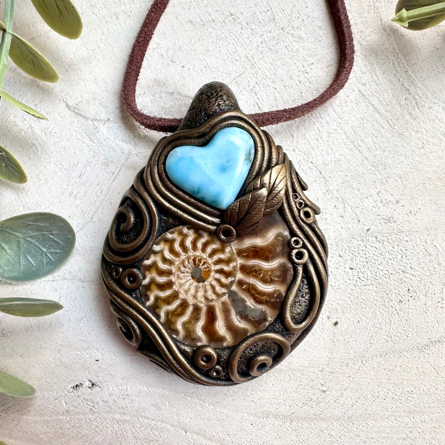 Fantasy ocean inspired crystal jewelry necklace featuring larimar heart and ammonite fossil