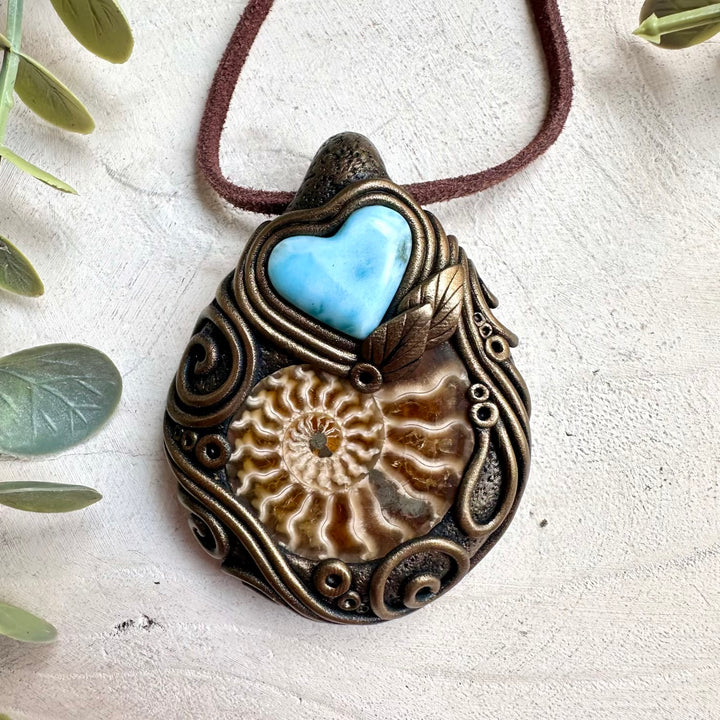 Fantasy ocean inspired crystal jewelry necklace featuring larimar heart and ammonite fossil