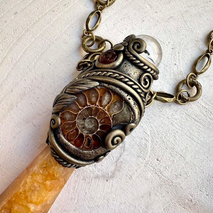 Close up of clear quartz sphere on golden healer crystal wand