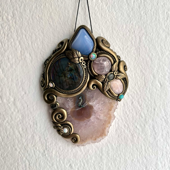 Colorful Ethiopian Opal and Clear Topaz add luminous accents to this handmade Amethyst and Labradorite gemstone wall art. Inspired by traditional crystal associations of intuition, peace, love, compassion, creativity, clarity, transformation and spiritual connection, this handmade gemstone wall decoration is perfect for collectors of natural crystals, healing crystal decor and unique artisan spiritual artwork.