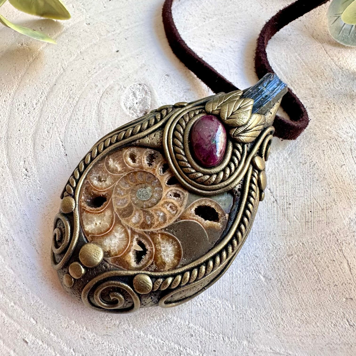 Unique gemstone necklace featuring a natural Ammonite with deep black Tourmaline and red Ruby.
