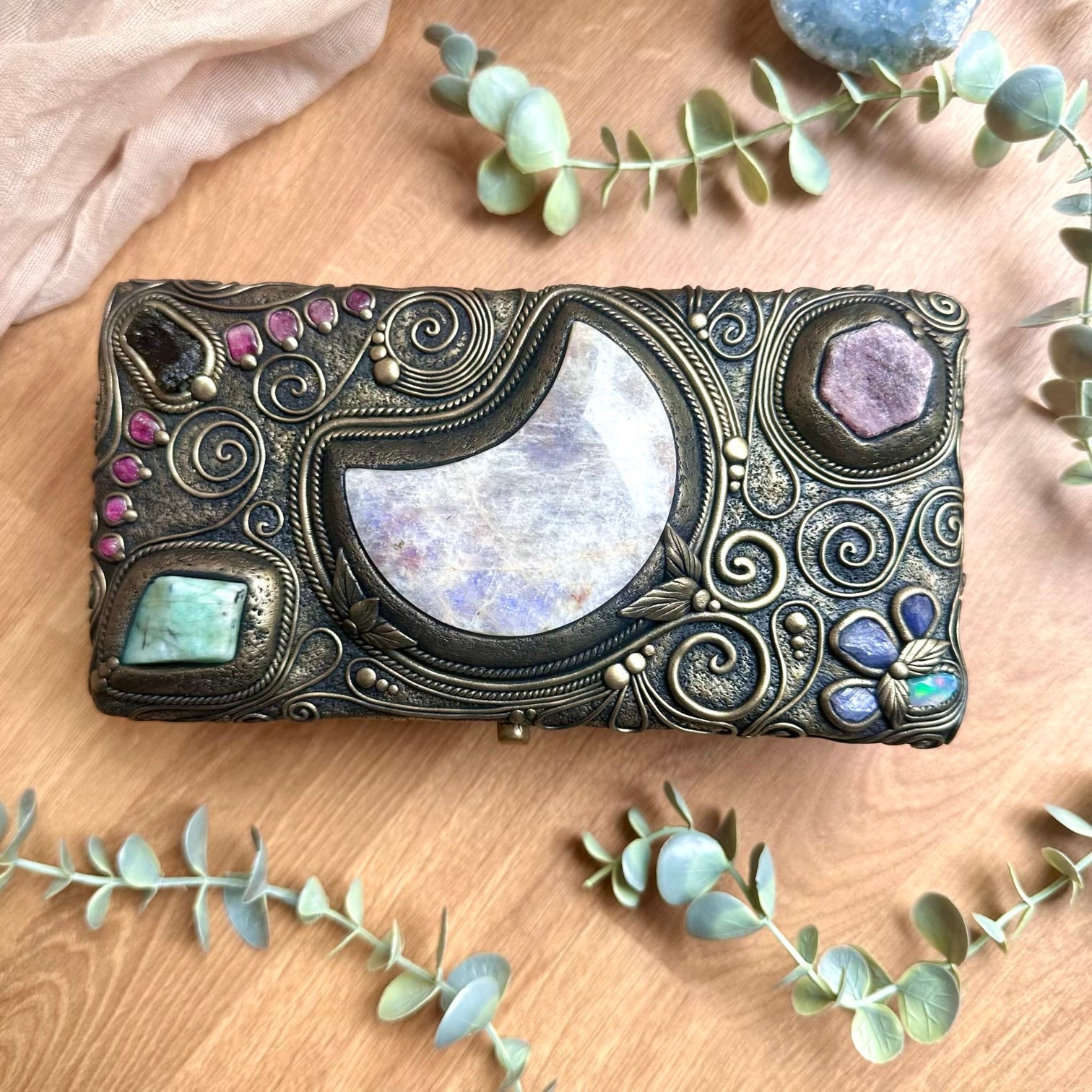 Handmade box decorated with crystals and gems including a large moonstone moon, moldavite and raw Ethiopian opal