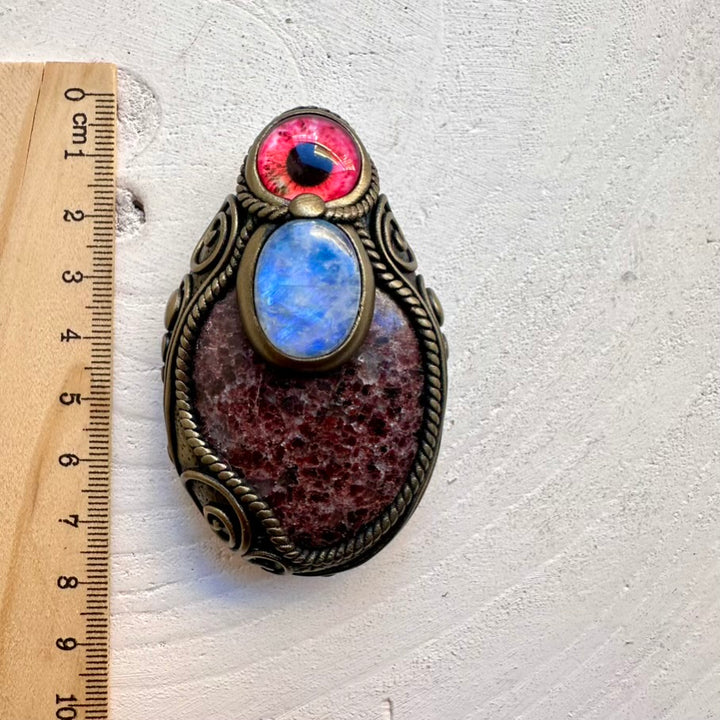Spiritual ritual talisman necklace featuring a large red Garnet stone and Rainbow Moonstone eye amulet, handmade with intention.