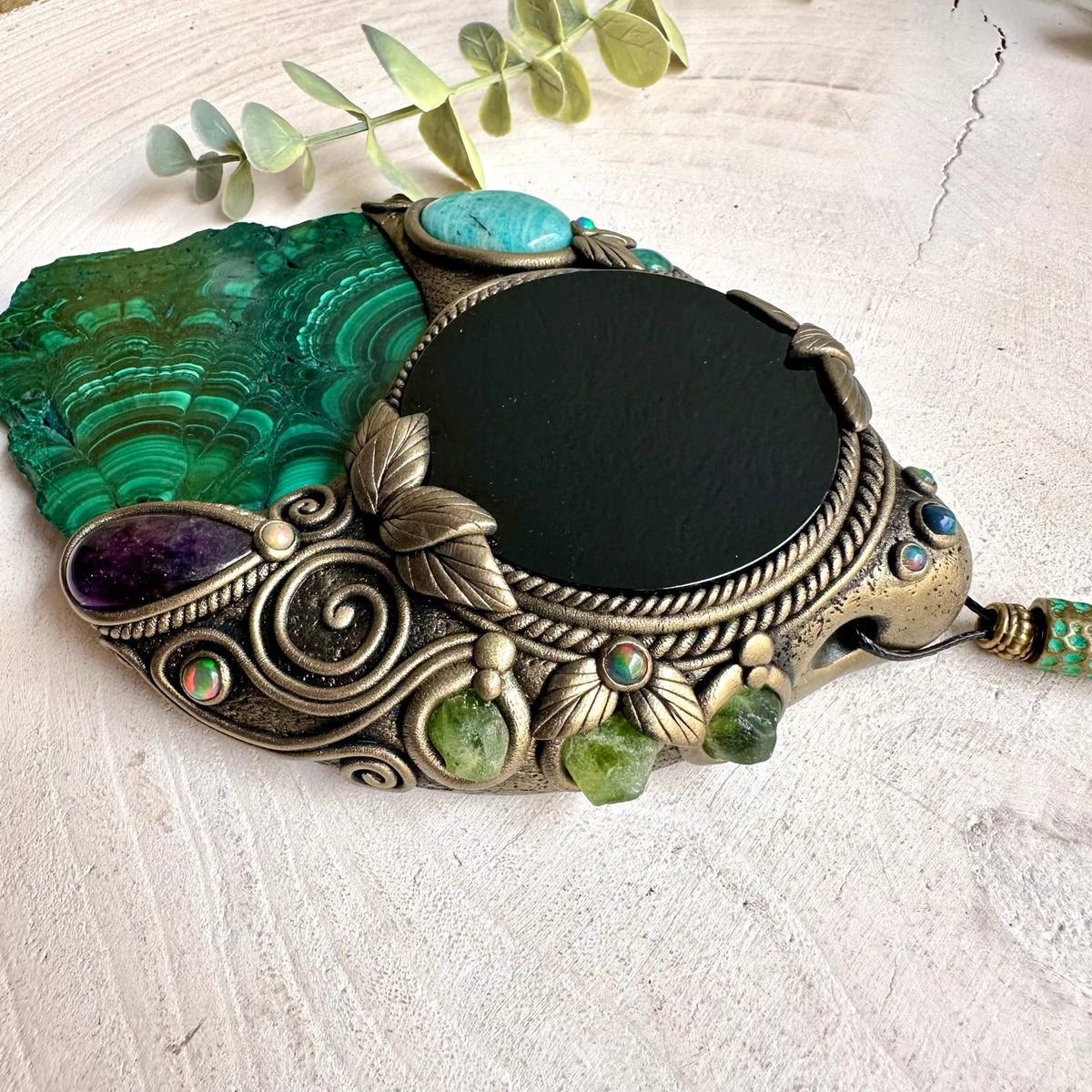 Handmade Natural Malachite wall hanging with Black Obsidian mirror, a one of a kind spiritual crystal home decor piece adorned with Amazonite, Amethyst, Peridot and Black Ethiopian Opal.