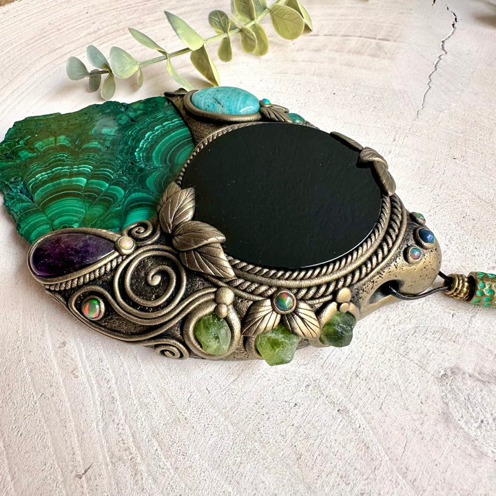 Handmade Natural Malachite wall hanging with Black Obsidian mirror, a one of a kind spiritual crystal home decor piece adorned with Amazonite, Amethyst, Peridot and Black Ethiopian Opal.
