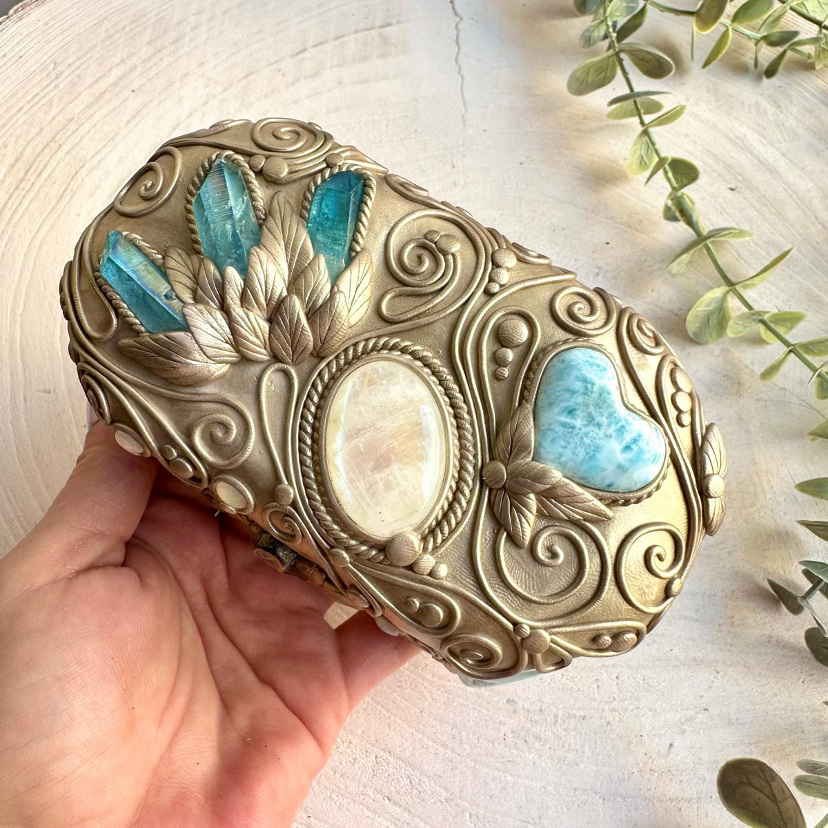 Artisan decorated box showcasing Aquamarine, Larimar Heart, Rainbow Moonstone and Ethiopian Opal.