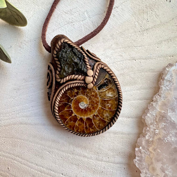 Handmade necklace featuring moldavite and ammonite fossil