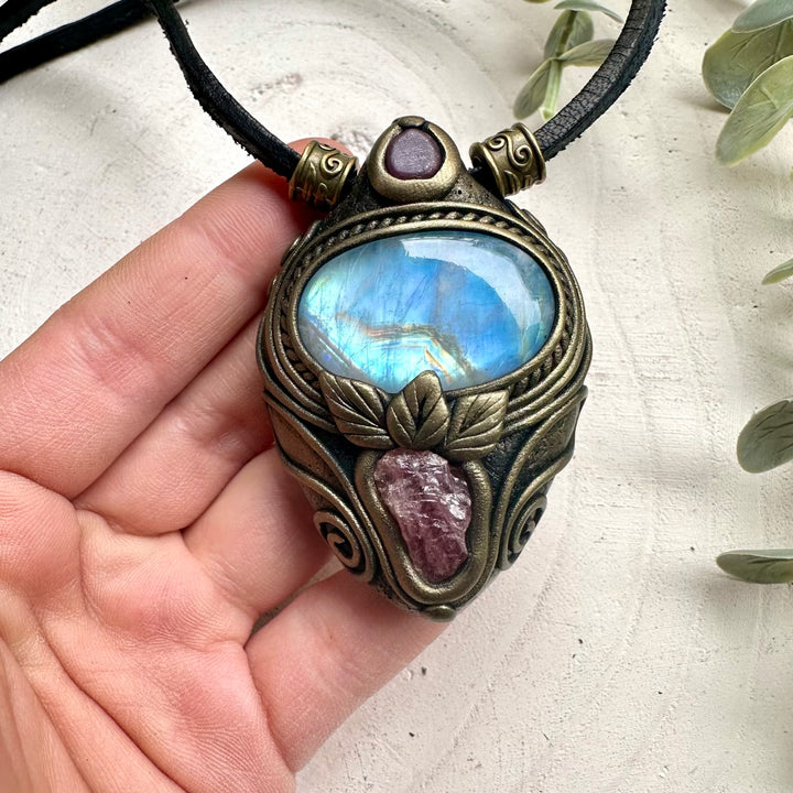 Natural rainbow moonstone paired with raw spinel and ruby in a pendant