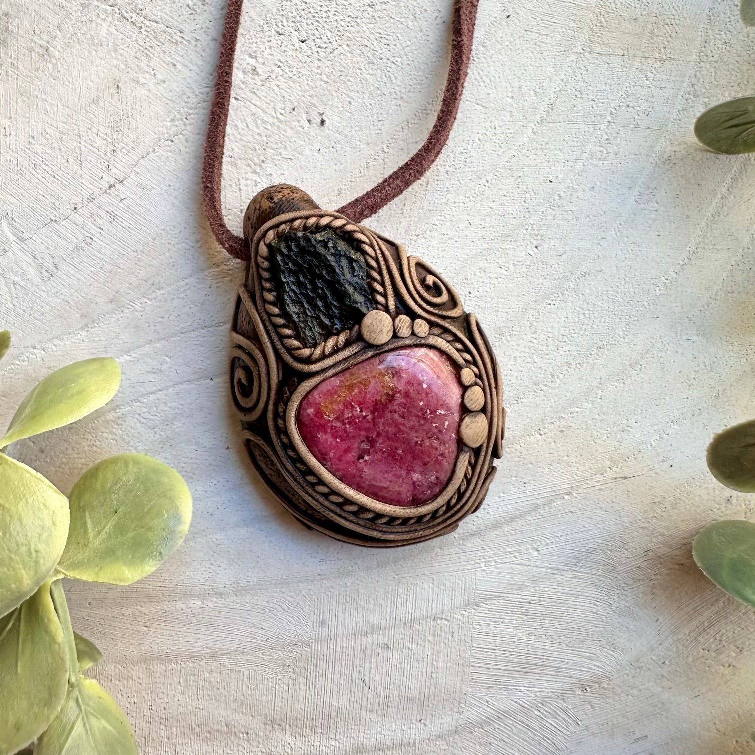 Spiritual pendant featuring rhodonite gemstone and raw moldavite