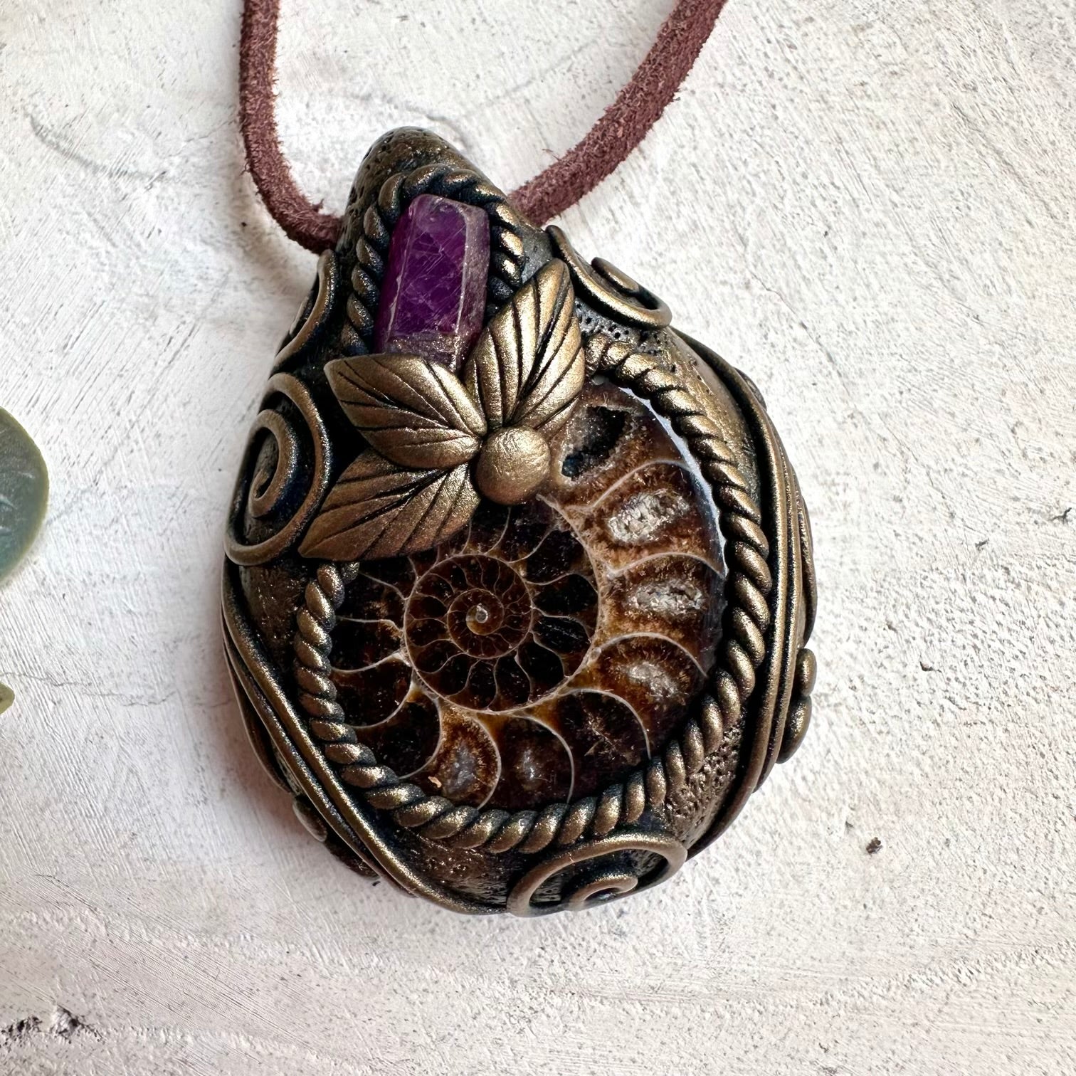 Healing crystal necklace handcrafted with genuine Ammonite and Ruby gemstones in an artisan pendant design.