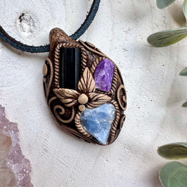 Blue calcite paired with black tourmaline and charoite in a necklace