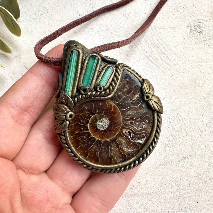 Healing gemstone necklace featuring green tourmaline crystals and ammonite fossil centerpiece