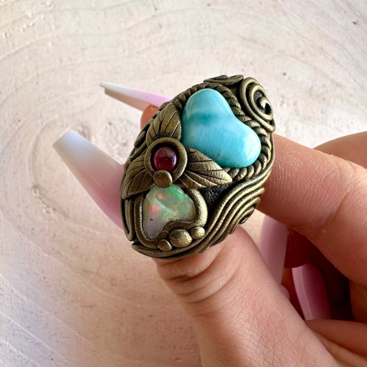 Handmade crystal jewelry combining Larimar, Raw Ethiopian Opal and Rhodolite Garnet in boho clay setting.