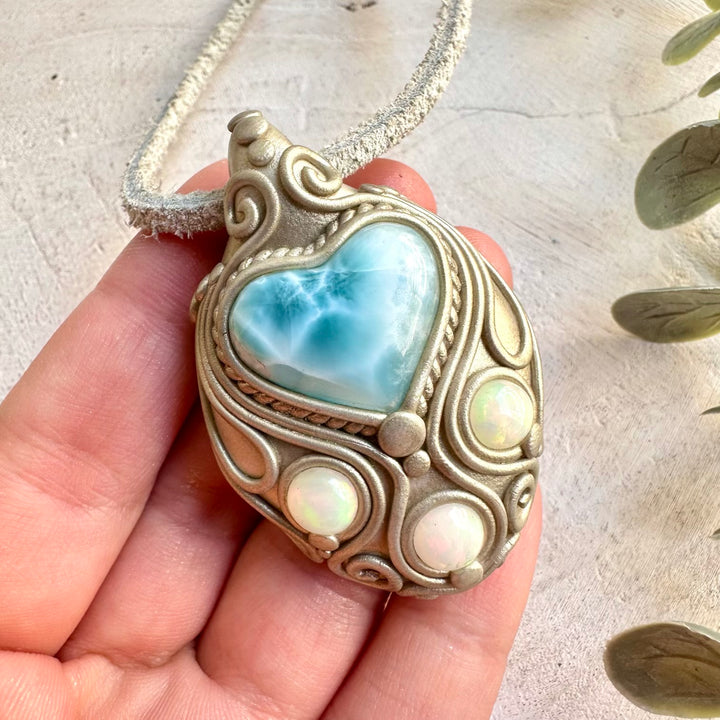 Handmade Larimar Heart and Ethiopian Opal pendant necklace, a one of a kind gemstone jewelry piece combining soothing ocean-blue Larimar with the natural flashes of colorful Ethiopian Opal. An enchanting spiritual necklace inspired by tranquility, creativity, emotional balance, intuition and personal transformation.