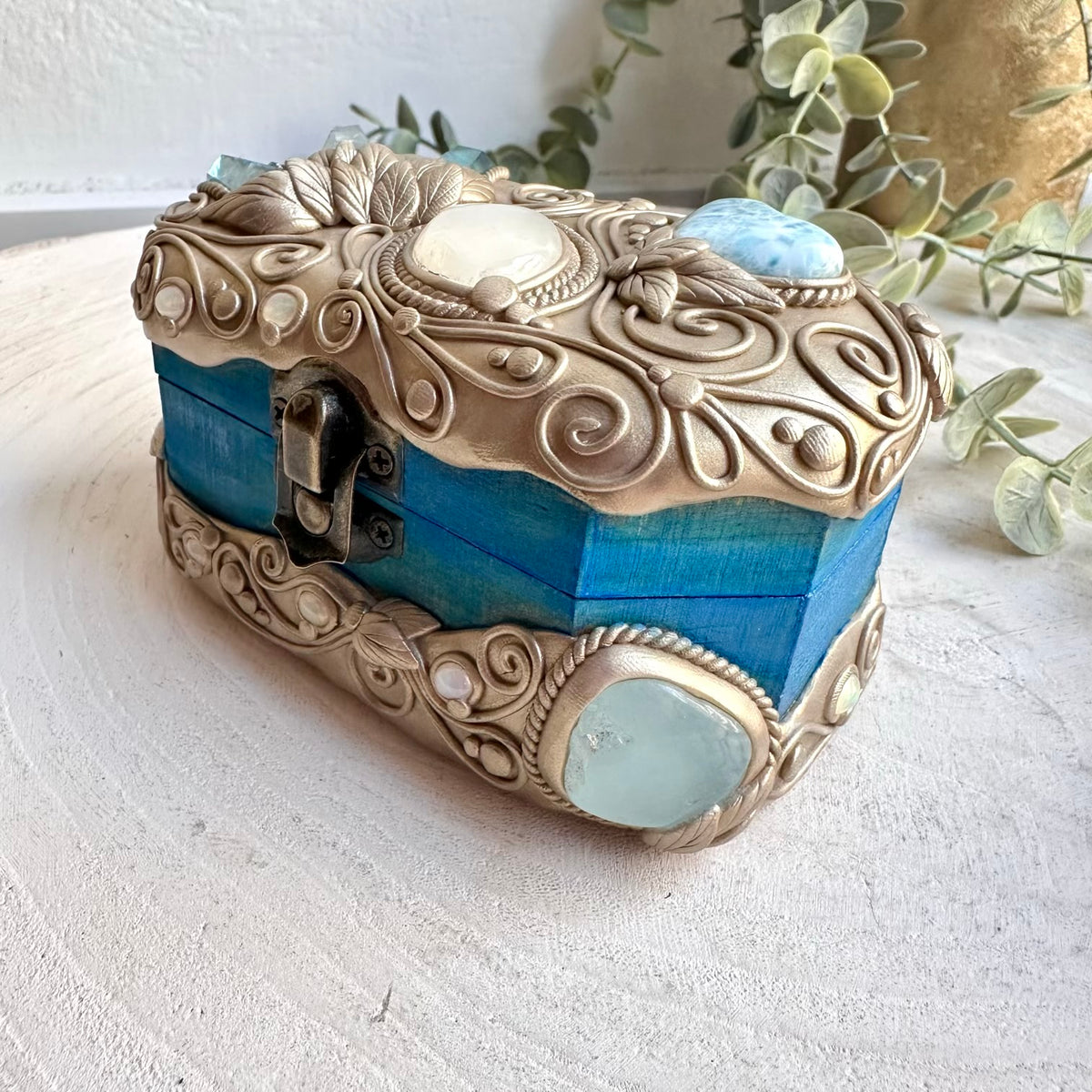 Unique spiritual home decor box decorated with natural crystals and colorful gemstones.