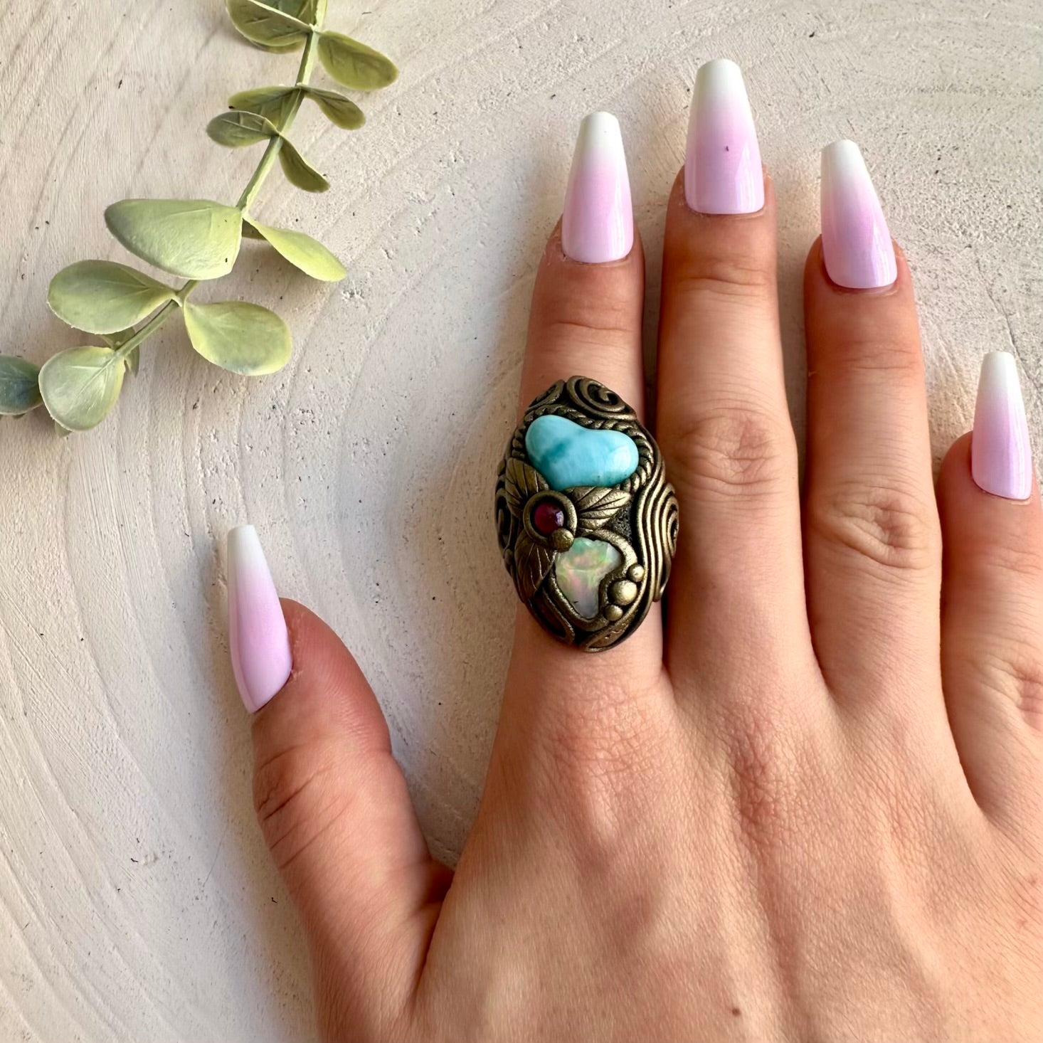 Handmade Larimar Heart ring featuring Raw Ethiopian Opal and Rhodolite Garnet, a one of a kind gemstone jewelry piece combining soothing ocean-blue Larimar with luminous Opal and rich red Garnet.