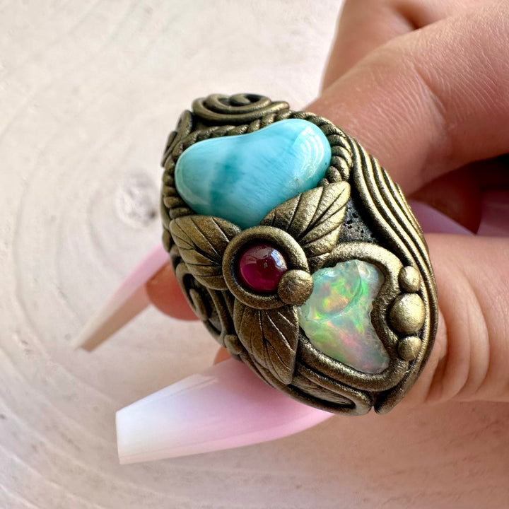 Handmade gemstone jewelry combining a soft blue Larimar Heart with Raw Ethiopian Opal and Garnet.