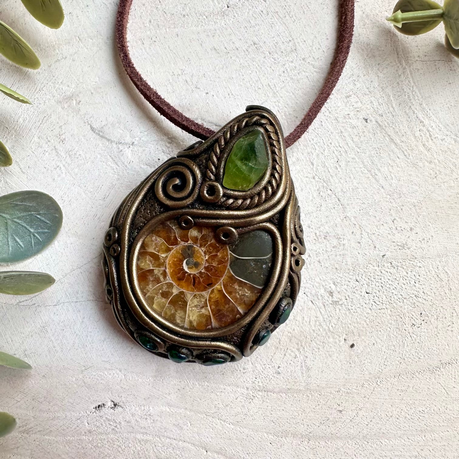 Metaphysical jewelry necklace featuring ammonite fossil, Ethiopian opal, and peridot crystals