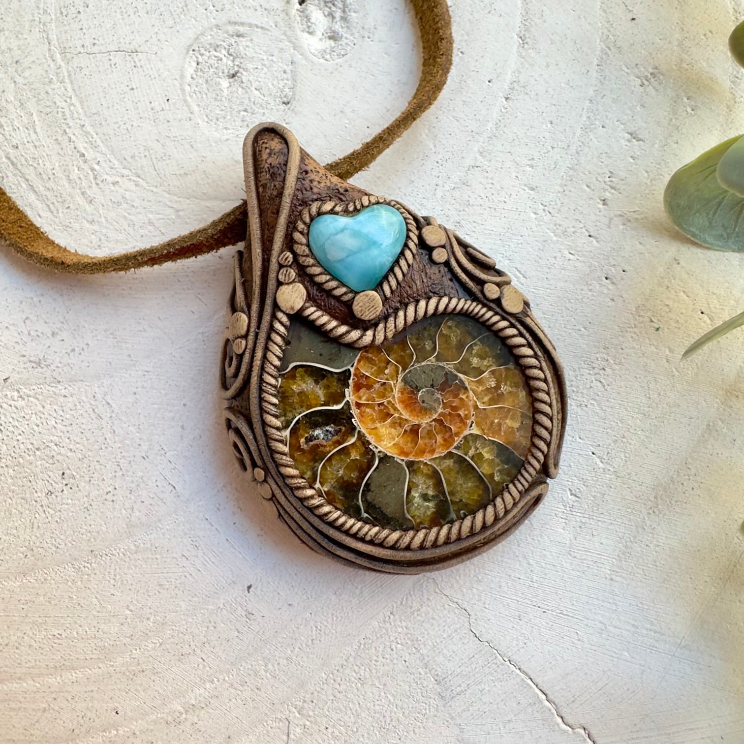 Handmade crystal necklace featuring ammonite fossil and Larimar heart
