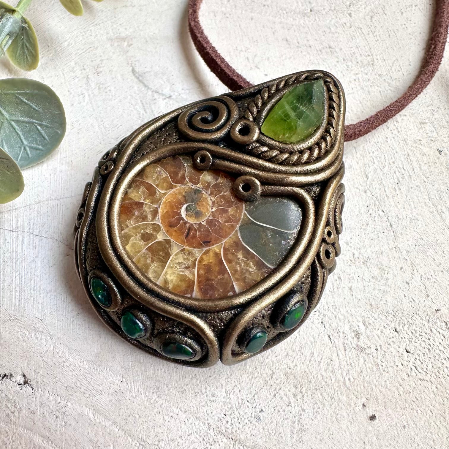 Mineral specimen necklace featuring ammonite fossil and black Ethiopian opal crystal details