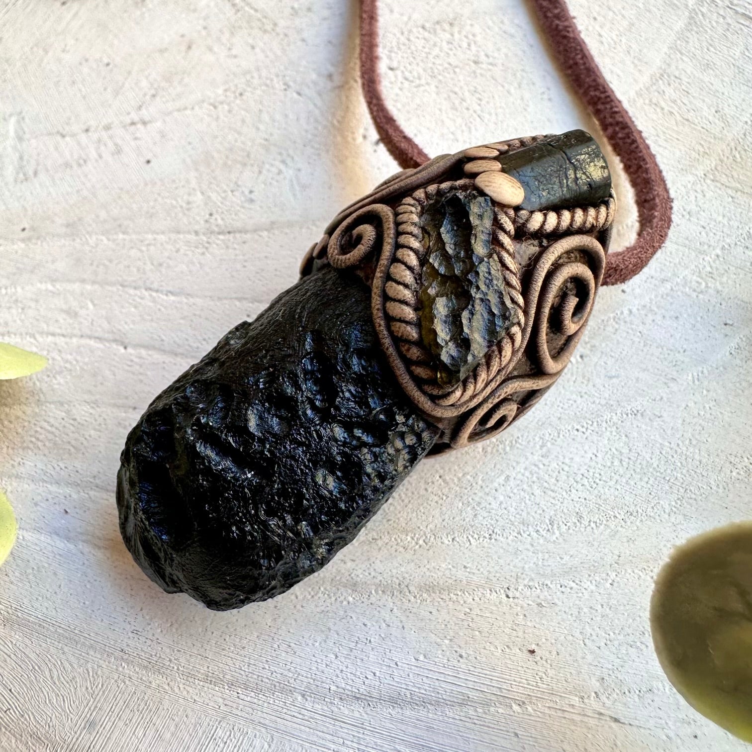 Close up of black tektite moldavite and black tourmaline pendant