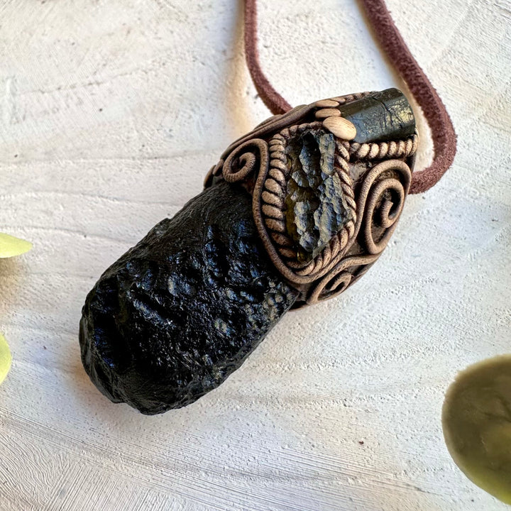 Close up of black tektite moldavite and black tourmaline pendant