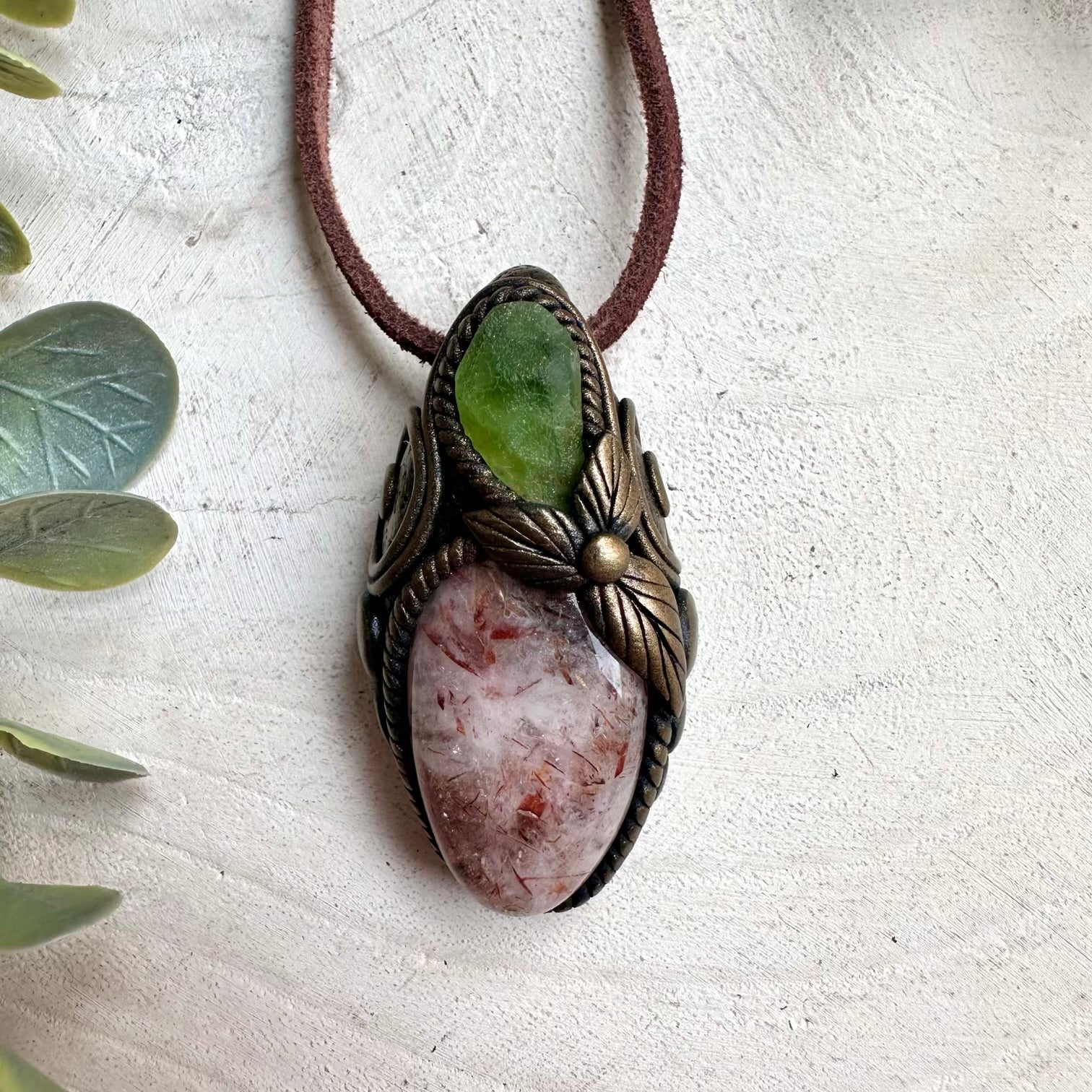 Metaphysical gemstone necklace with Hematite Quartz crystal pendant and vibrant green Peridot accents.