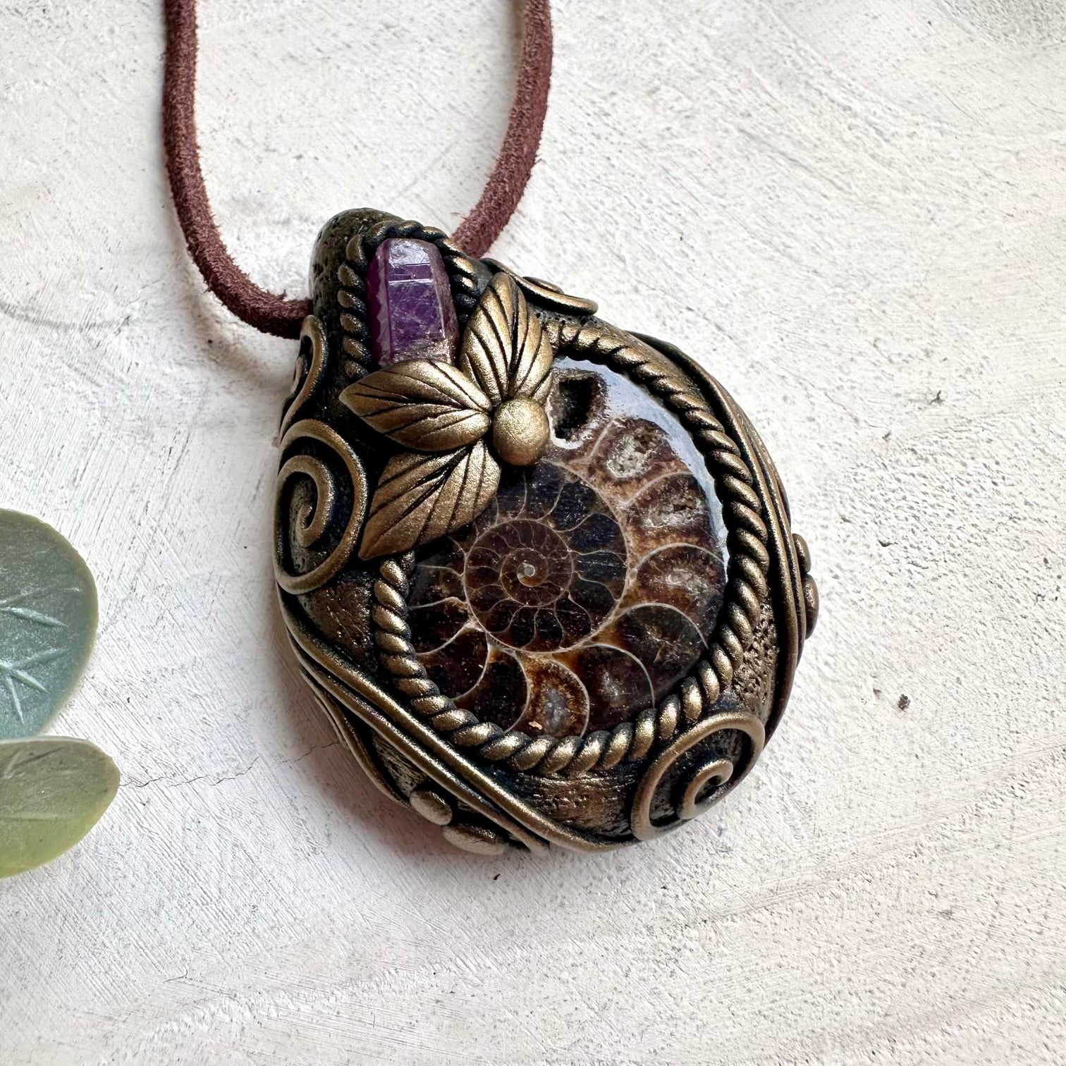 Metaphysical gemstone necklace with Ammonite fossil pendant and deep red Ruby crystal accents.